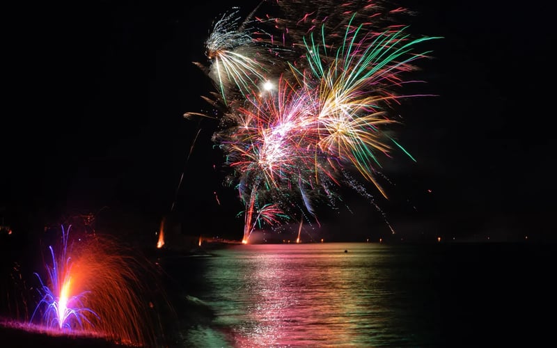 A fireworks display over a body of water at night