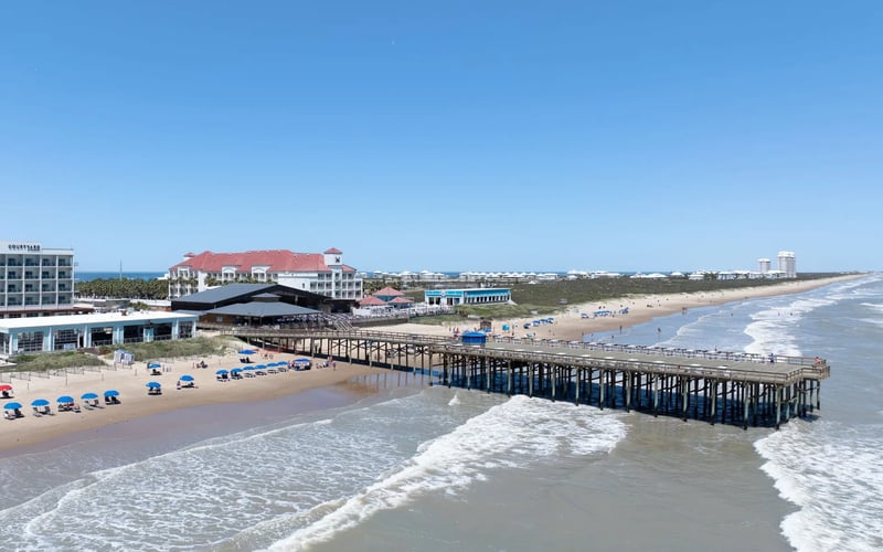 An aerial view of a pier leading into the ocean.