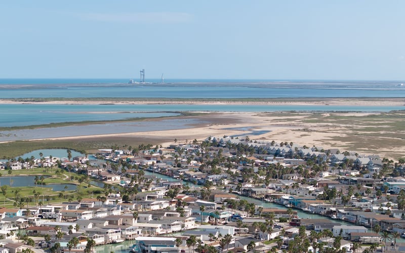 An aerial view of a residential area next to a body of water.